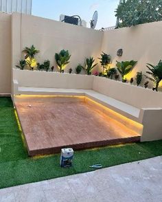 an outdoor area with artificial grass and plants on the ground, surrounded by white walls