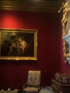 a painting hanging on the wall next to a chair in a room with red walls