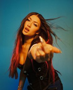 a woman with red hair pointing her finger at the camera while wearing a leather jacket