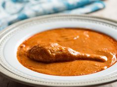 a white bowl filled with sauce on top of a wooden table