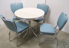 a white table with six blue chairs around it