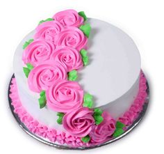 a white cake with pink frosting roses on it