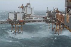 an oil rig in the middle of a large body of water with waves around it