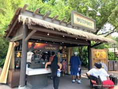 people are standing at the entrance to an outdoor coffee shop with tiki kiosk