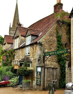 an old brick building with ivy growing on it's sides and a bicycle parked in front