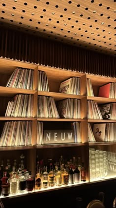 the shelves are filled with various records and liquors in glass bottles on top of them