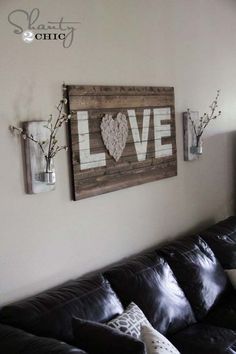 a living room with black leather couches and love signs on the wall above them