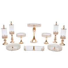 an assortment of glass and gold - plated candlesticks, cake plates, and dishes