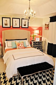 a bedroom decorated in peach, white and black with a chandelier above the bed