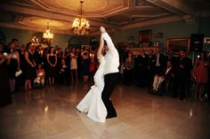 a bride and groom are dancing on the dance floor in front of an audience at their wedding reception