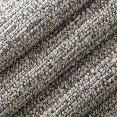 close up view of the texture of a tweed fabric with grey and white colors, as seen from above