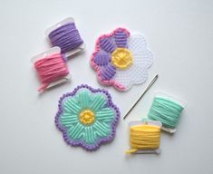 crochet flowers and yarn on a white surface