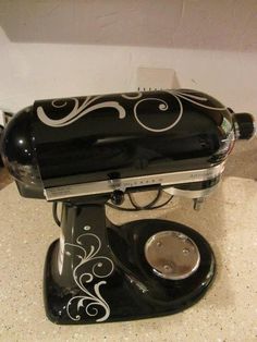 a black and silver coffee maker sitting on top of a counter next to a wall