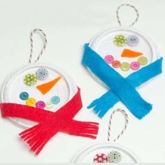 two ornaments made out of buttons and yarn are on display in front of a white background