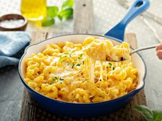 a blue skillet filled with macaroni and cheese