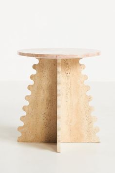 a round table with scalloped edges and a wooden base