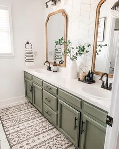 a bathroom with green cabinets and white tile on the floor is pictured in this image