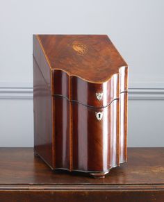 an old wooden box sitting on top of a table next to a wall and floor