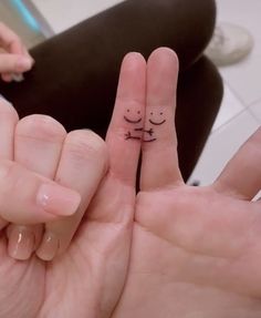 two fingers with small faces drawn on them