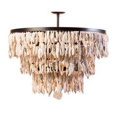 a chandelier made out of shells hanging from a ceiling fixture with a white wall in the background