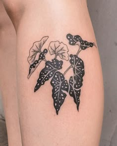 a close up of a person's legs with tattoos on them and flowers in the middle