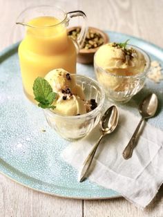 two desserts are sitting on a plate with spoons