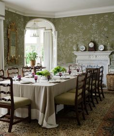 a dining room table is set with place settings and flowers on the centerpieces