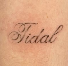 a close up of a person's arm with the word tidal written on it