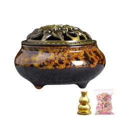 a brown and black pot with gold accents next to a small golden vase on a white background