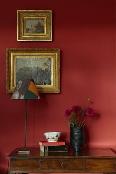 a room with red walls and pictures on the wall