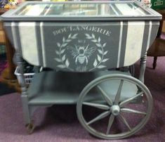 an old fashioned ice chest with wheels on the floor in front of a store display case