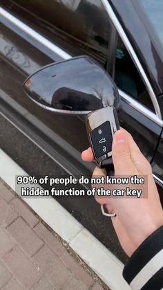 a person holding a cell phone in front of a car with the words 90 % of people do not know the hidden function of the car key