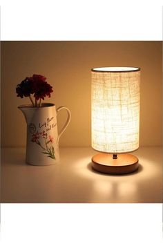 a table lamp with a flower pot next to it