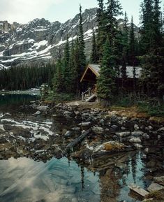 a cabin on the shore of a mountain lake