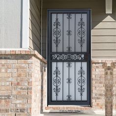 an iron gate in front of a brick house