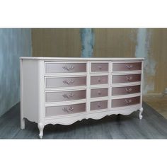 a white dresser with pink drawers in a room