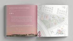 an open book showing the layout of a city with buildings and streets in pink hues