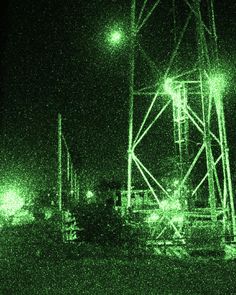 the lights are shining brightly in the night sky over an area with water and power lines