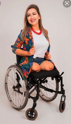 a woman in a wheelchair posing for the camera with her hands on her hips and smiling