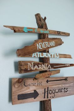 a wooden sign that has some writing on it and arrows pointing to different locations in the same direction