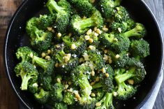 broccoli florets and corn in a skillet on a wooden table