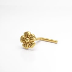 a pair of gold colored flower shaped hair pins on a white background with clippings