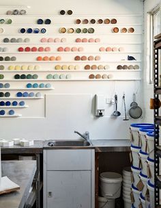 a kitchen with lots of pots and pans hanging on the wall above the sink