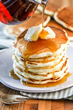 a stack of pancakes with syrup being drizzled on top