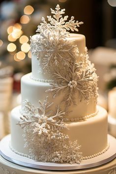 a three tiered white wedding cake decorated with snowflakes