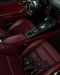 the interior of a sports car with red leather seats and steering wheel, including an electronic console