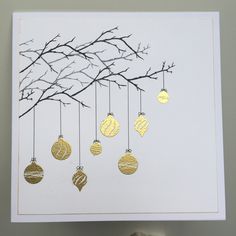 a card with gold ornaments hanging from a tree branch