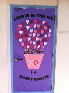 a door decorated with hearts and the words love is in the air