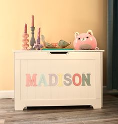 a toy chest with toys on top of it and the word madison written in multicolored letters