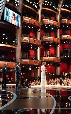 two people standing on stage in front of an audience